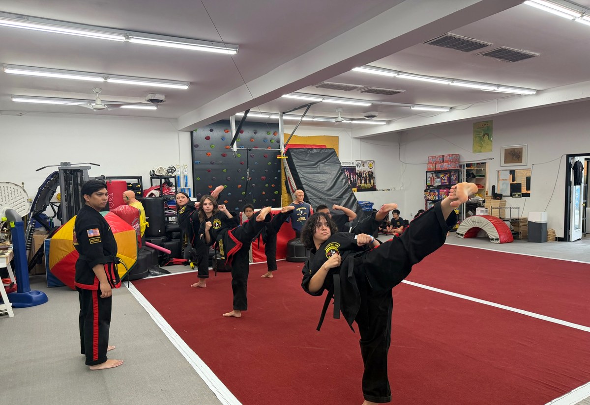 Black-uniform martial artists performing an action sequence.
